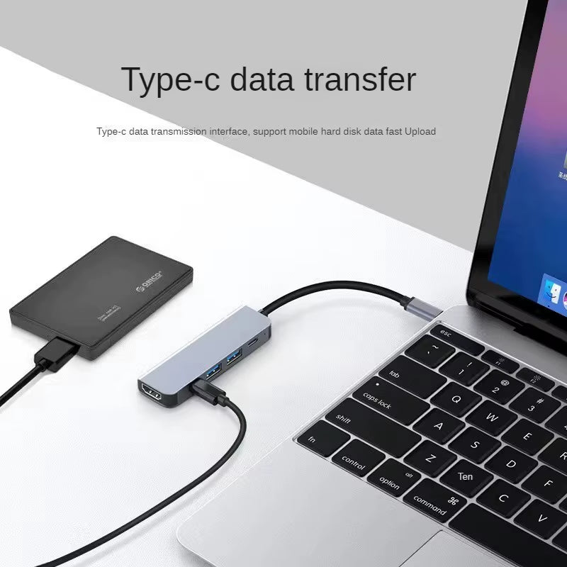 USB-C hub's second Type-C port connected to an external hard drive for data transfer, plugged into a MacBook