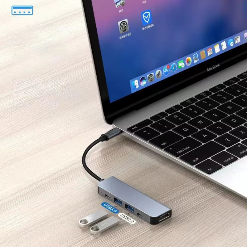 USB-C hub plugged into a MacBook with two flash drives connected to the USB 3.0 and USB 2.0 ports